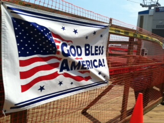 Photo of banner on fence stating God Bless America following Hurricane Sandy